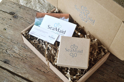 SeaMaid gift box and packaging in a cardboard box on a wooden surface