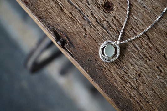 two molten silver rings, and pale seafoam blue sea glass, pendant on a silver chain