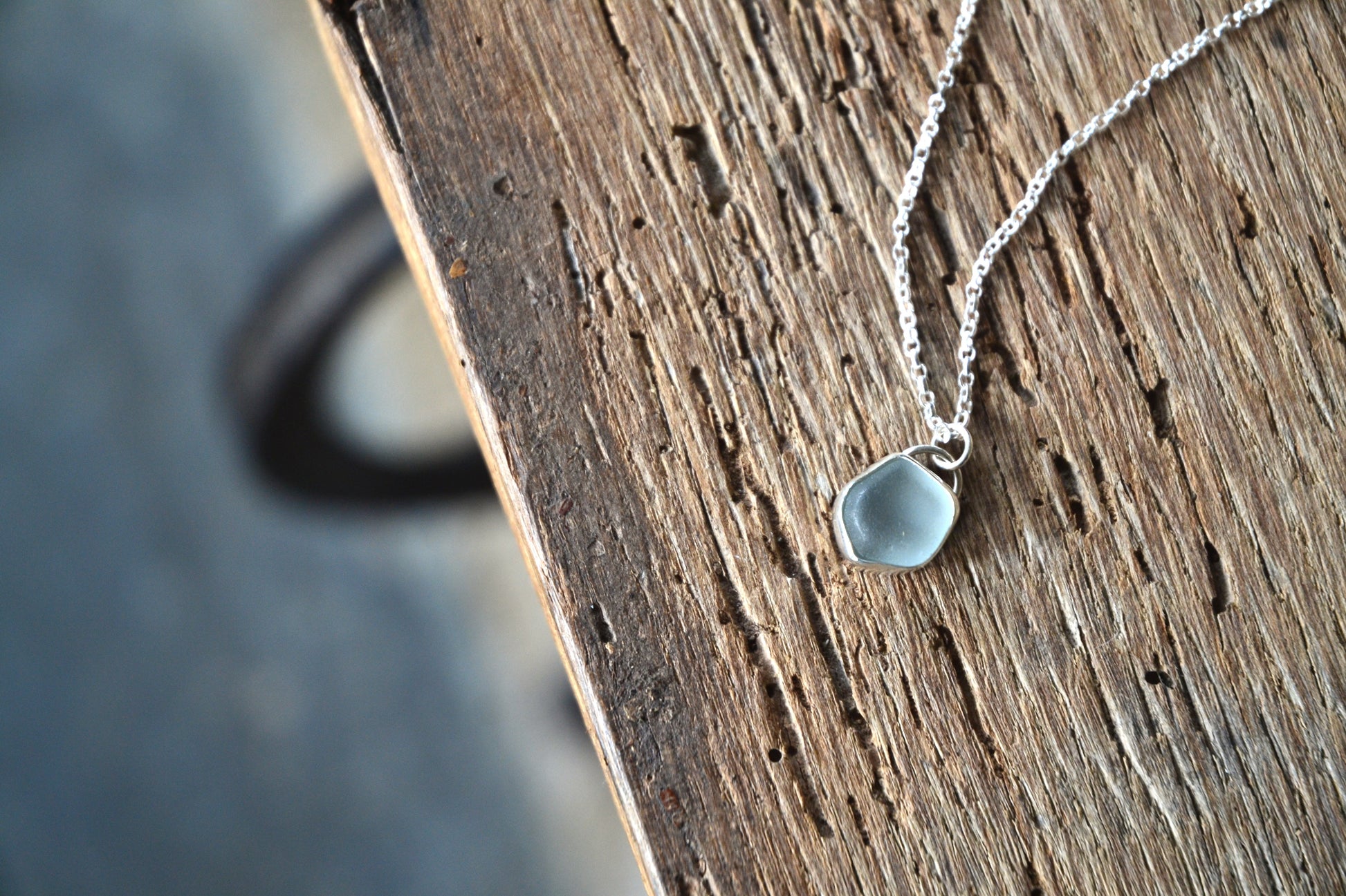 Necklace with a teardrop-shaped pendant on a wooden surface