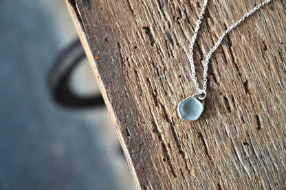 Necklace with a teardrop-shaped pendant on a wooden surface